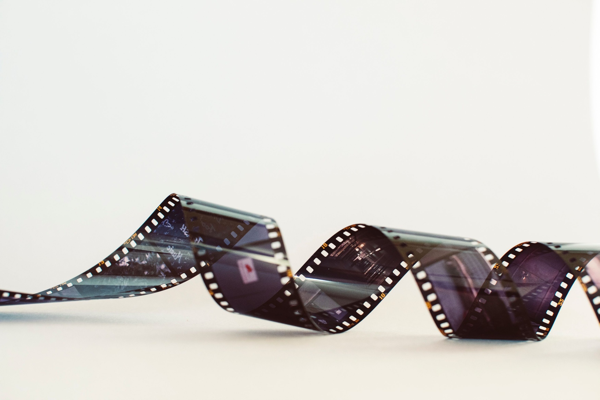 Film strip curled across a light surface, evoking classic cinema.